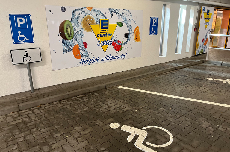 In erster Reihe zum Aufzug sind Parkplätze für Behinderte und Eltern mit Kind.